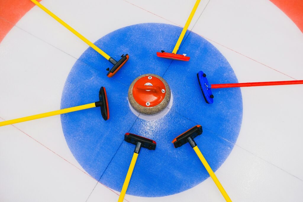 Curling stone and brushes in house